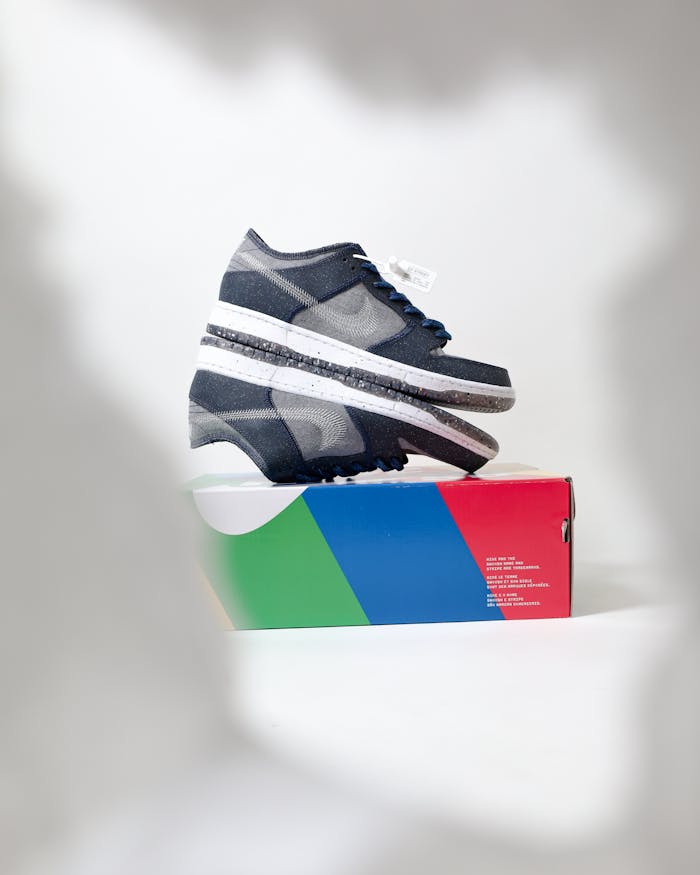 Close-up of trendy sneakers on a colorful shoe box with ample copy space in the background.